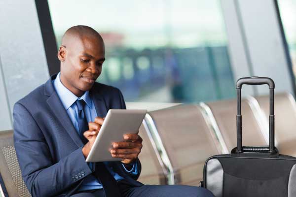 Business man at airport on a tablet