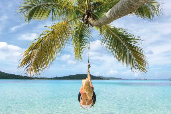 Woman in a tire swing on the beach