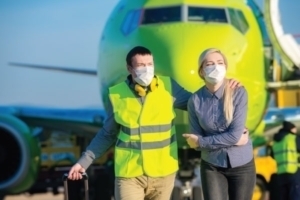 Man and women getting of plane with mask