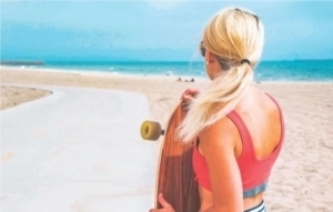 Woman on beach with skateboard